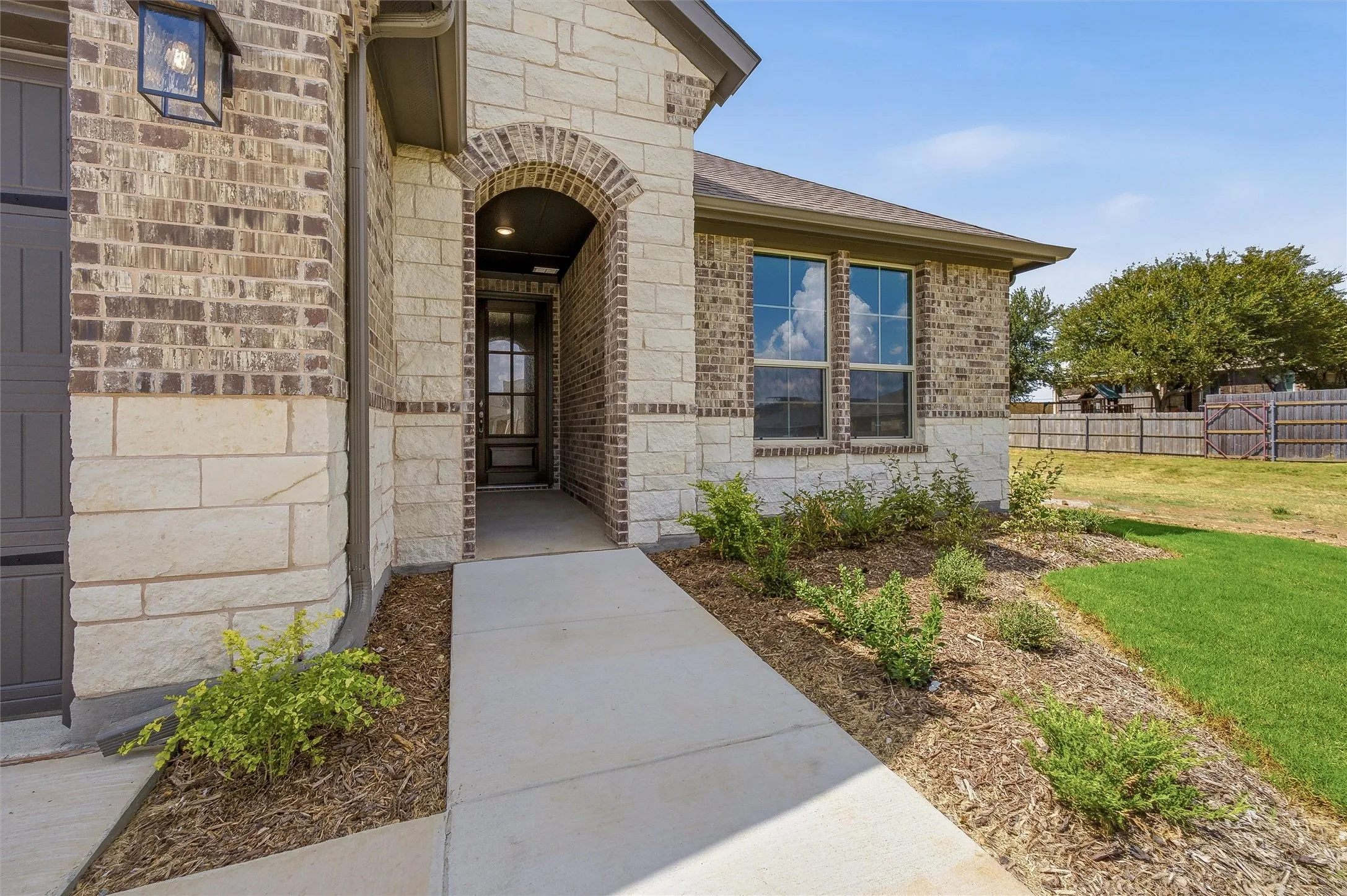 Stone and brick exterior with an arched entry