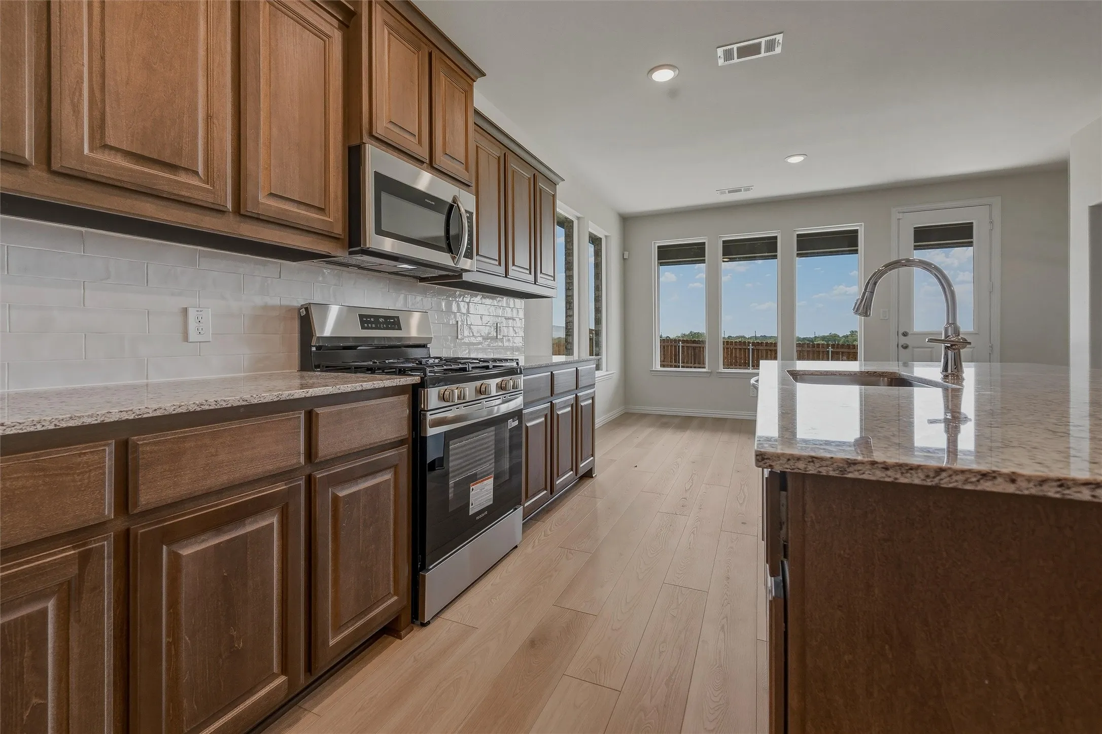 Kitchen featuring wood-finish cabinetry, stainless steel appliances, and light-colored countertops