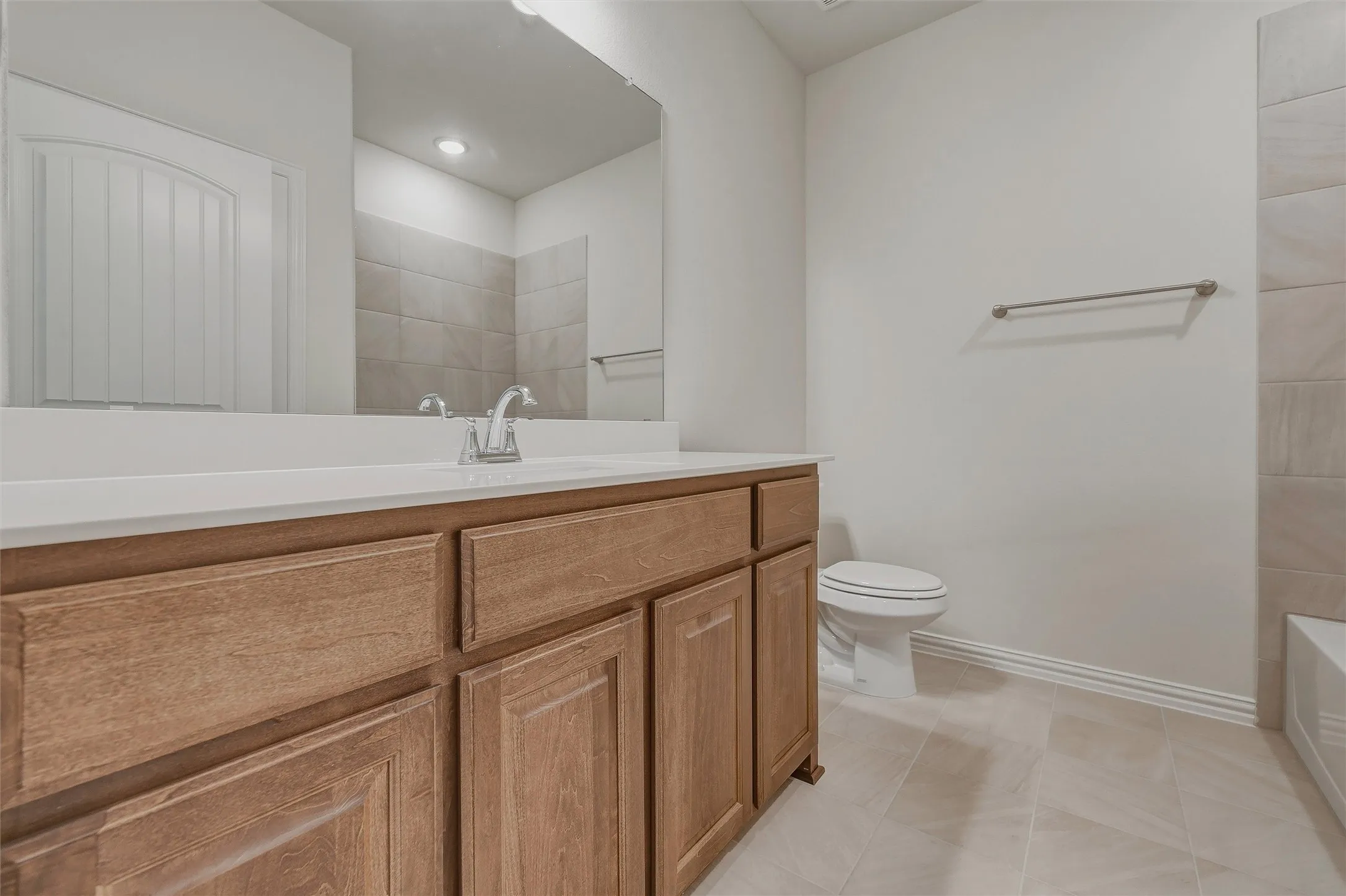 Wood-finish vanity with a white countertop and undermount sink