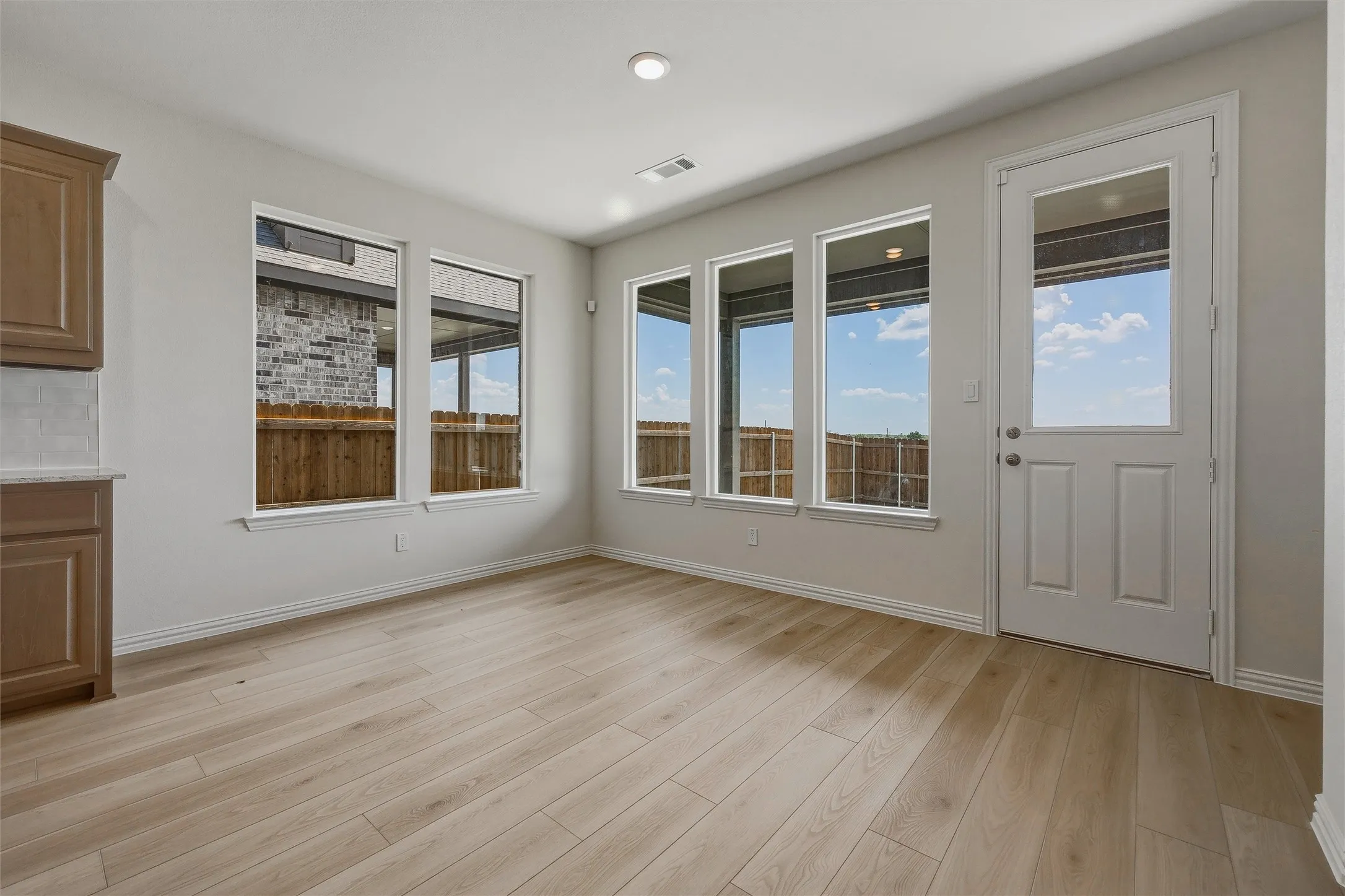 Wood-finish flooring throughout, recessed lighting, and multiple windows providing ambient light
