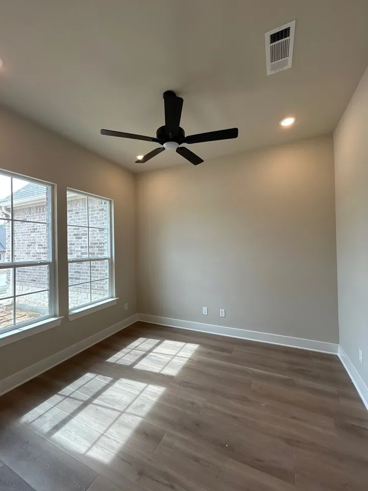 Wood-finish flooring, recessed lighting, ceiling fan, and two large windows