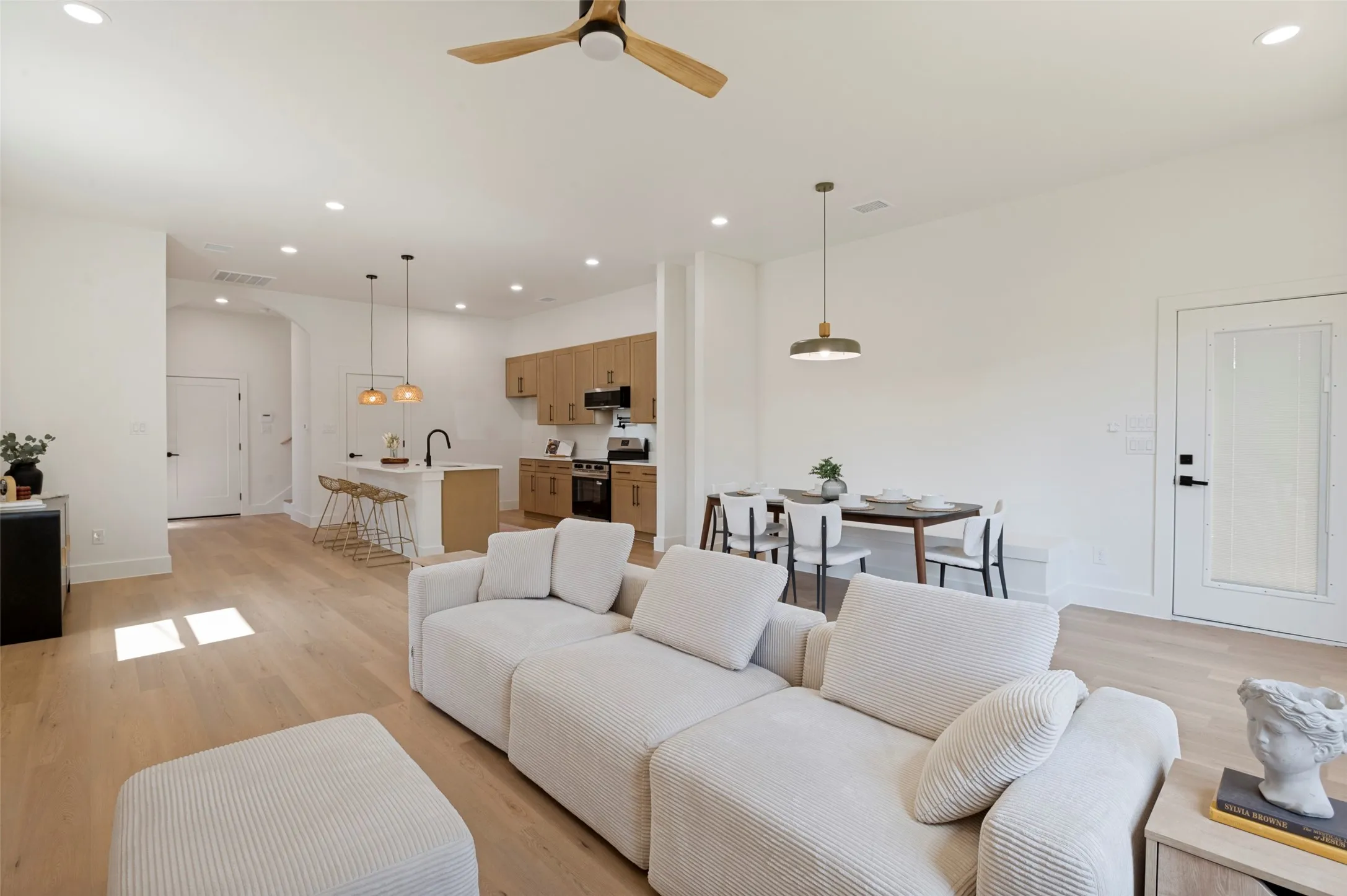 Open-concept living space featuring wood-finish flooring, recessed lighting, and a modern ceiling fan