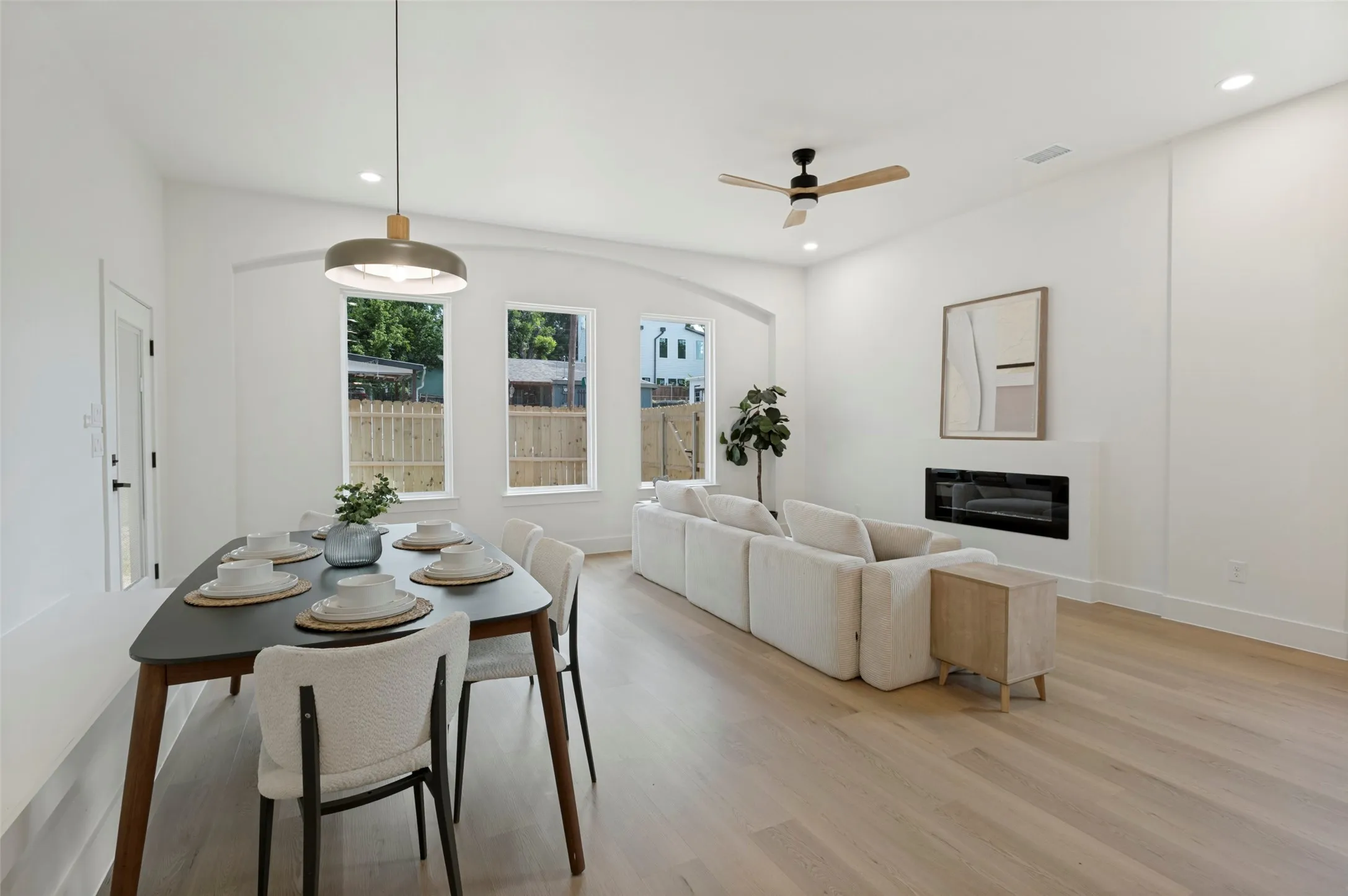 Open-concept living space featuring wood-finish flooring, recessed lighting, and a modern ceiling fan