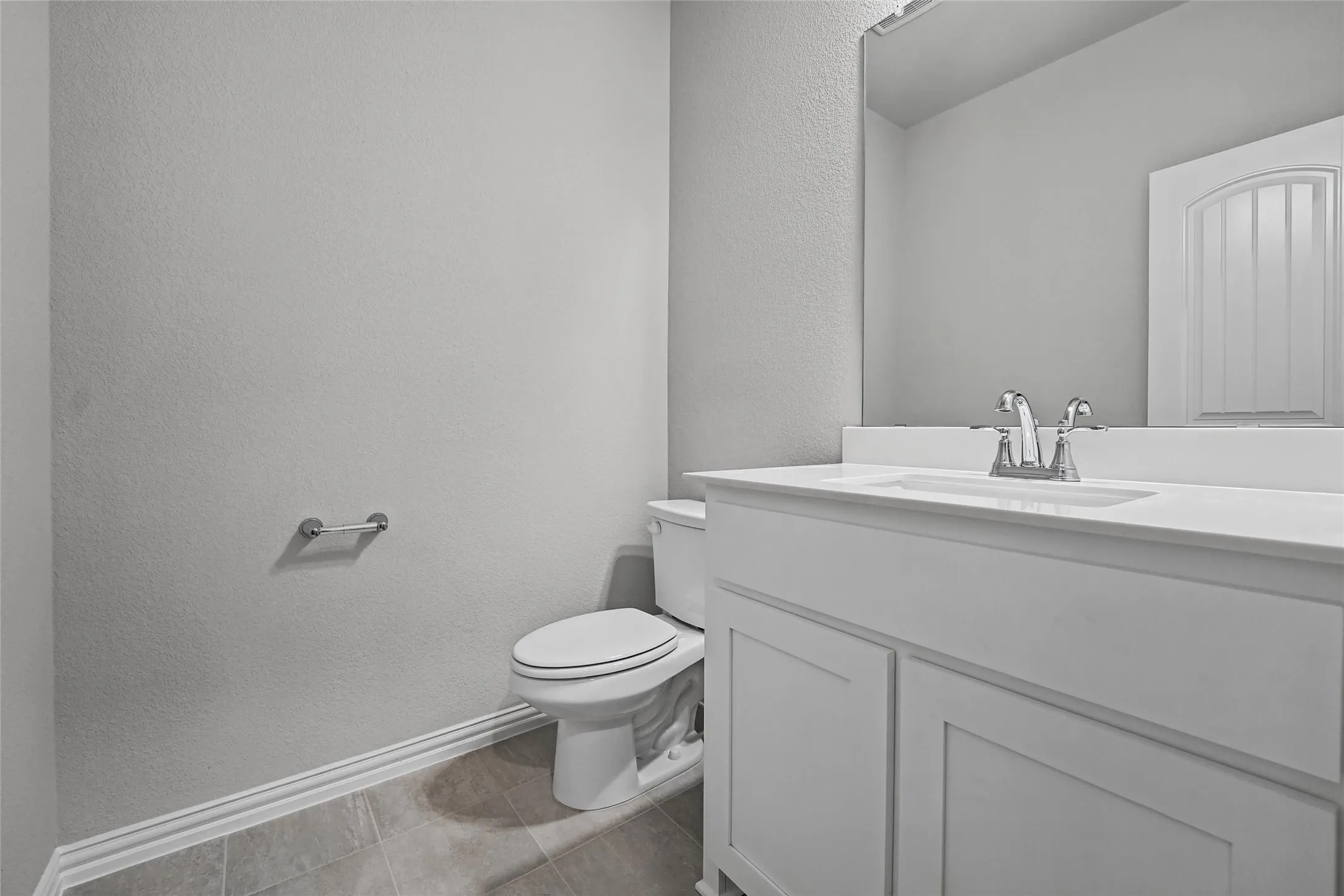 White vanity with integrated sink, chrome faucet, and rectangular mirror