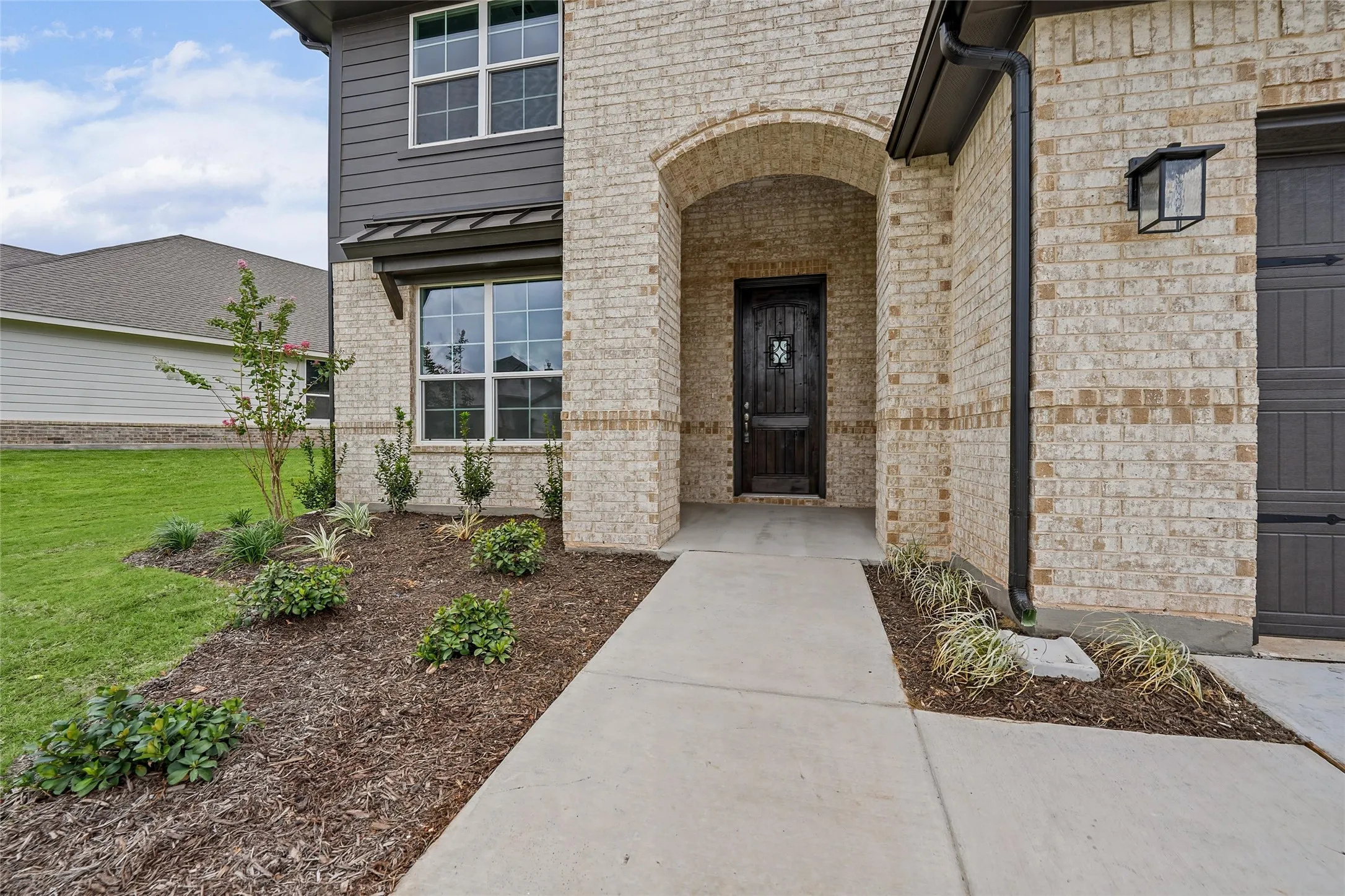 Light-toned brick exterior with dark horizontal siding
