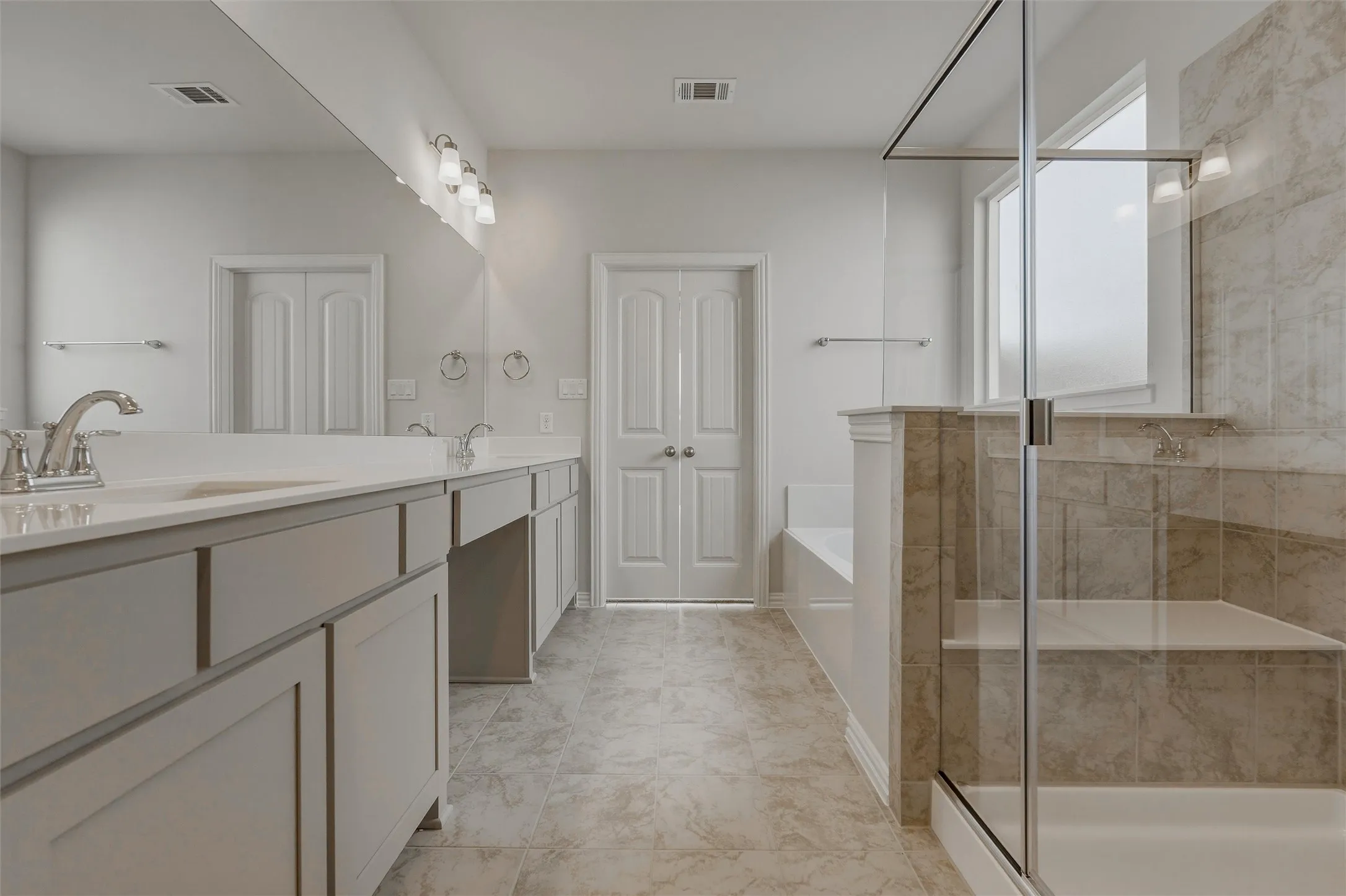 Dual vanity with undermount sinks, chrome fixtures, and light-toned countertops