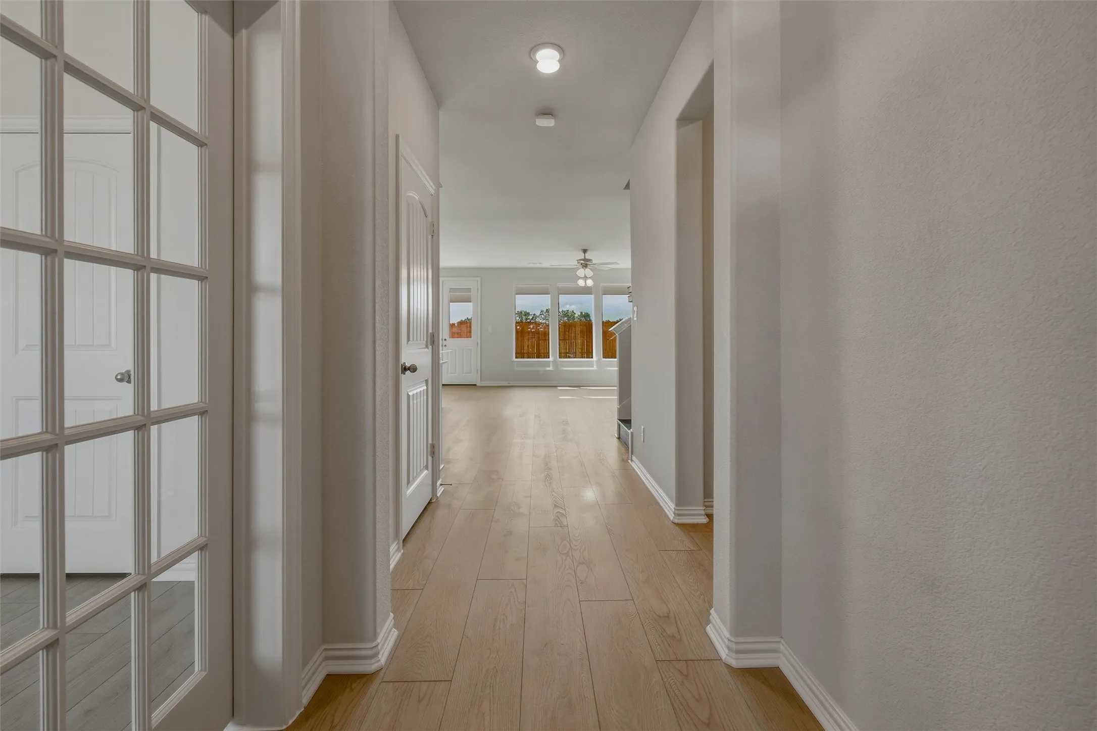 Hallway with wood-finish flooring, recessed lighting, and multiple paneled doors