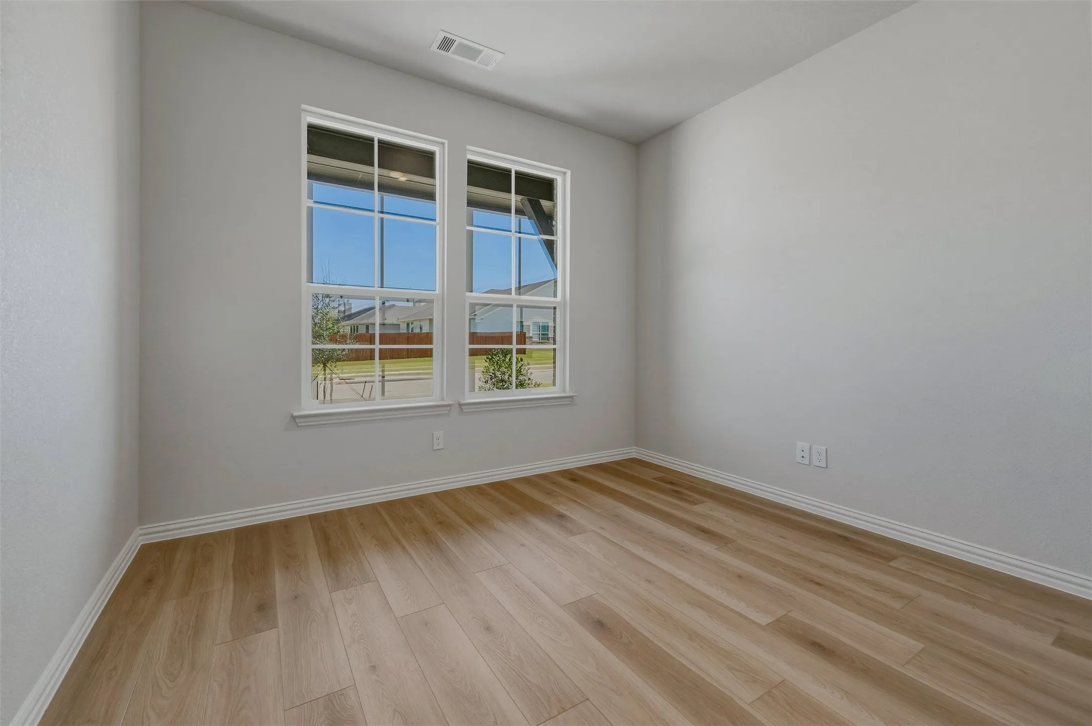 Light-toned wood-finish flooring complements neutral wall paint