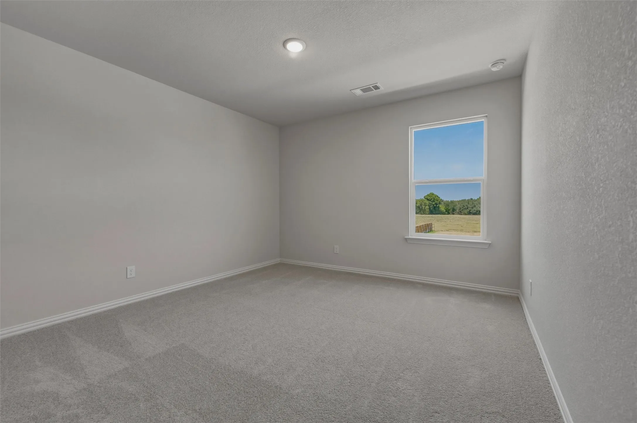 Neutral-toned carpeting, recessed ceiling lighting, and a double-pane window