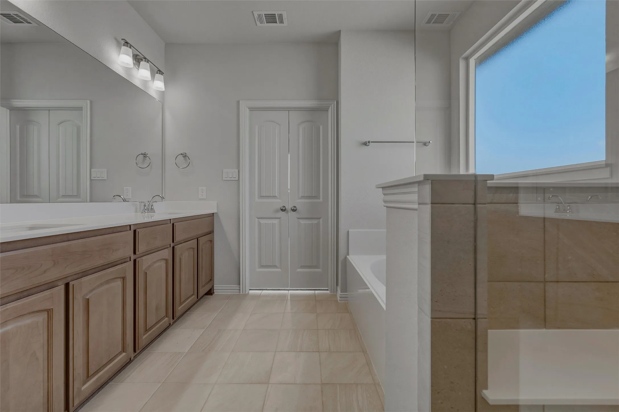 Dual vanity with wood-finish cabinetry and light-colored countertops