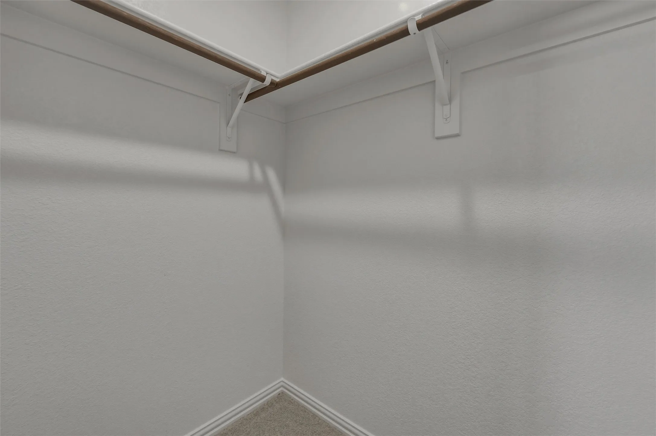 Built-in closet rods with white support brackets