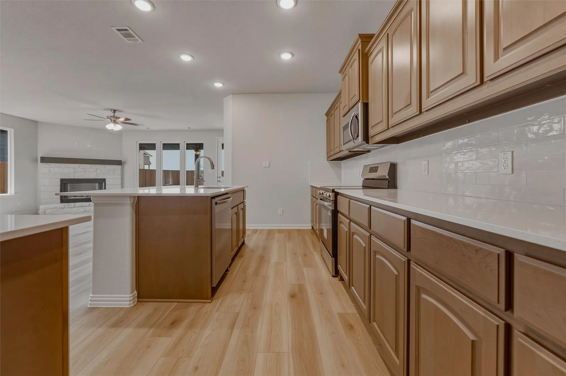 Kitchen featuring wood-finish flooring, recessed lighting, and a subway tile backsplash