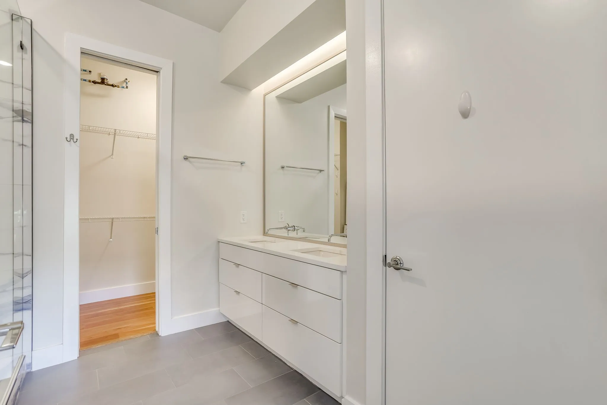 Modern bathroom featuring a dual vanity with white cabinetry