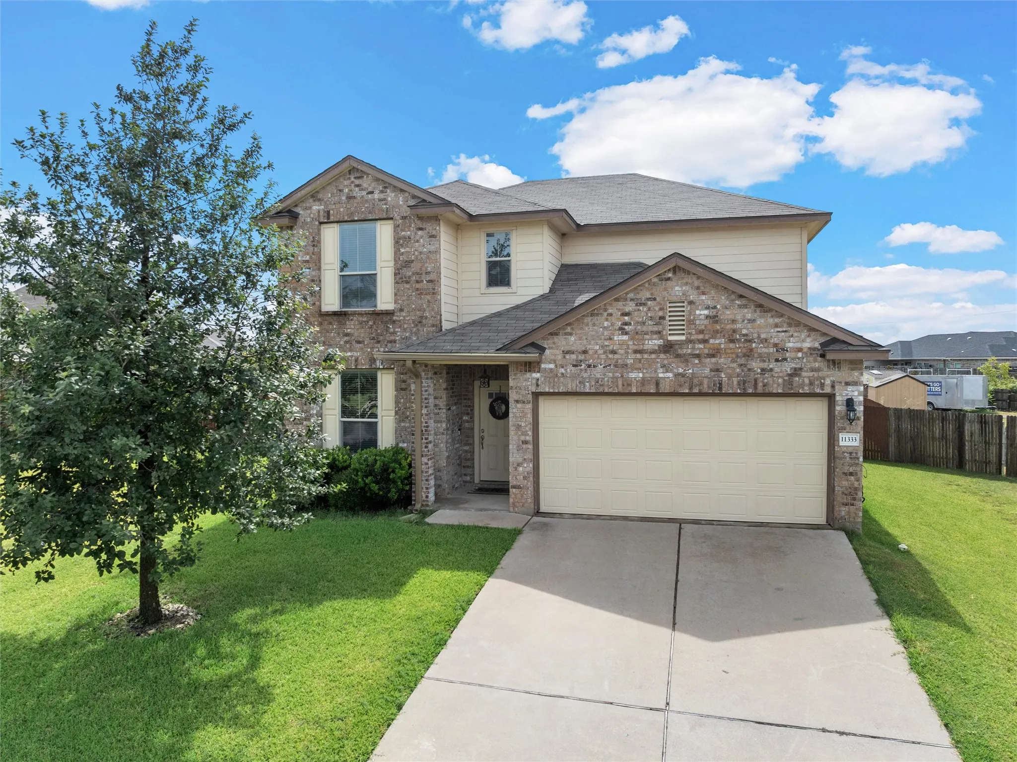 Two-story residence featuring a brick and siding exterior, an attached two-car garage, and a concrete driveway