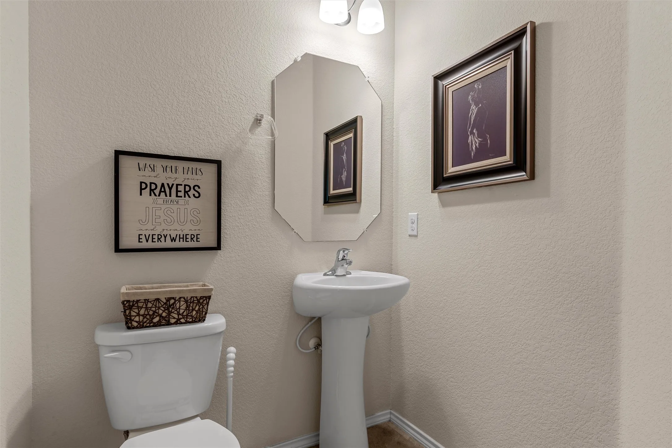 Pedestal sink with chrome faucet, complemented by an octagonal wall-mounted mirror
