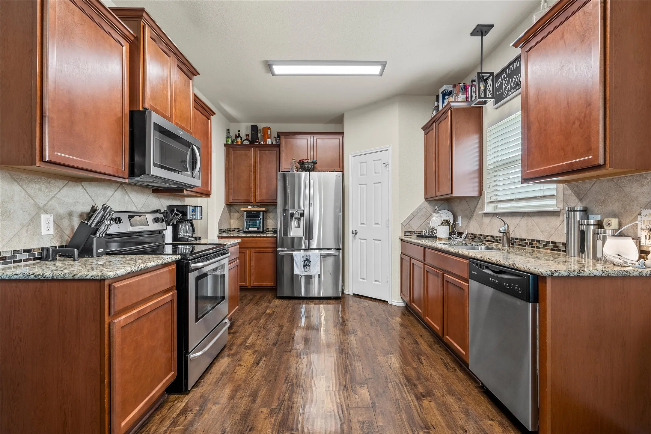 Kitchen featuring wood-finish flooring, granite countertops, and full-height cabinetry