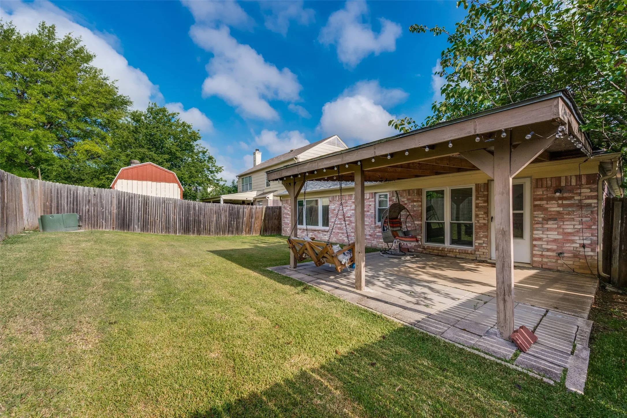 Backyard with large covered patio and swinging couch