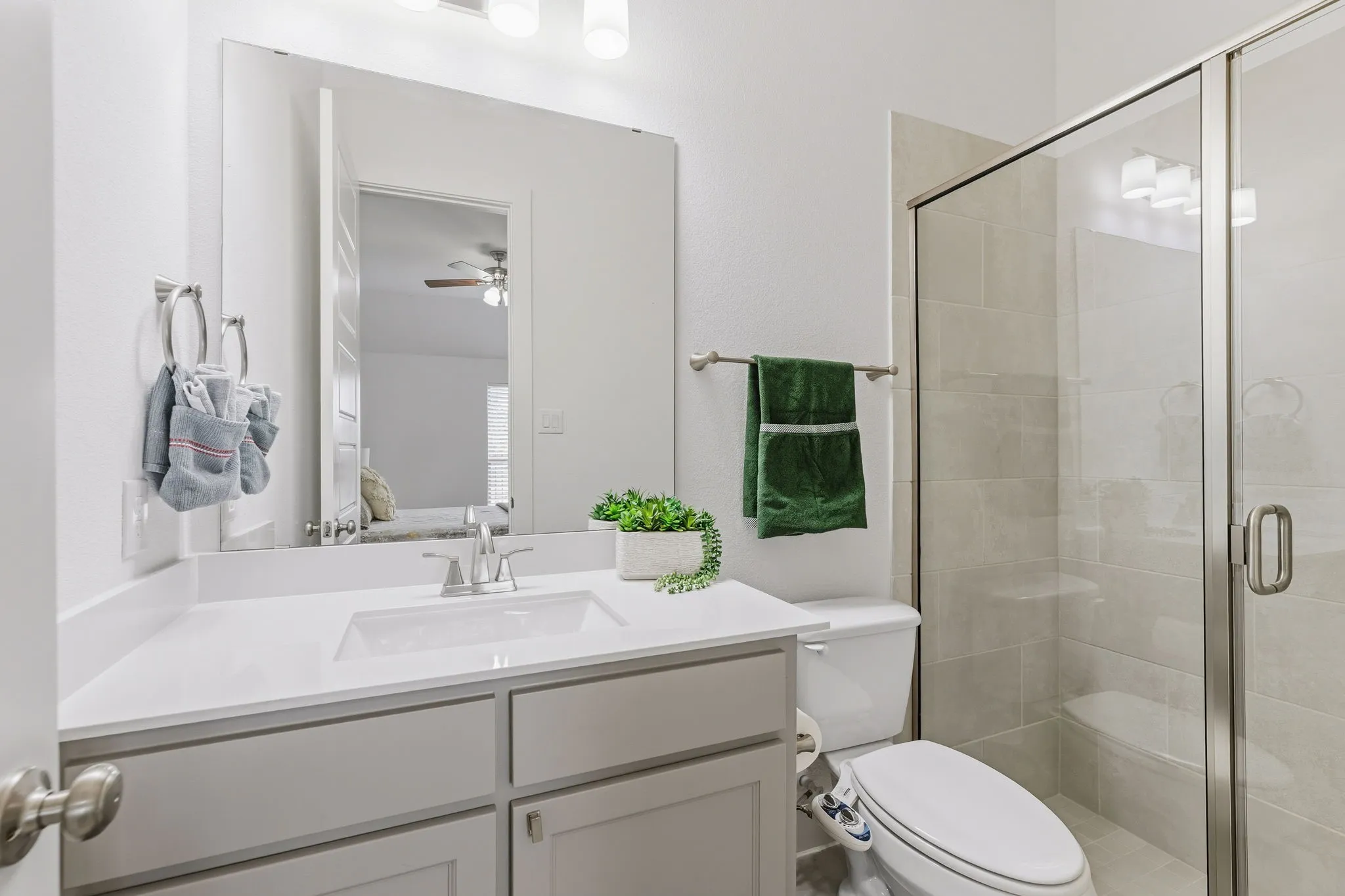 Bathroom featuring a white vanity with an integrated sink, polished chrome faucet, and overhead three-light fixture