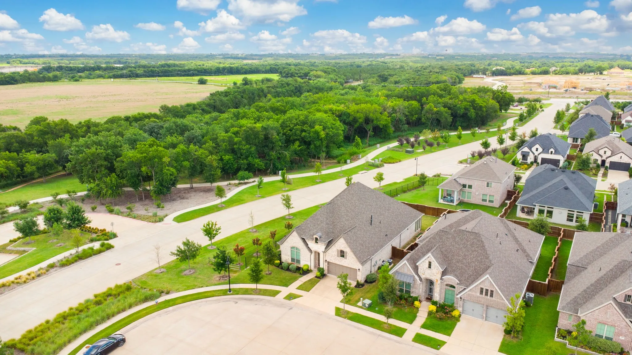 Aerial perspective featuring a residential street with homes showcasing varied architectural styles and multiple garage doors
