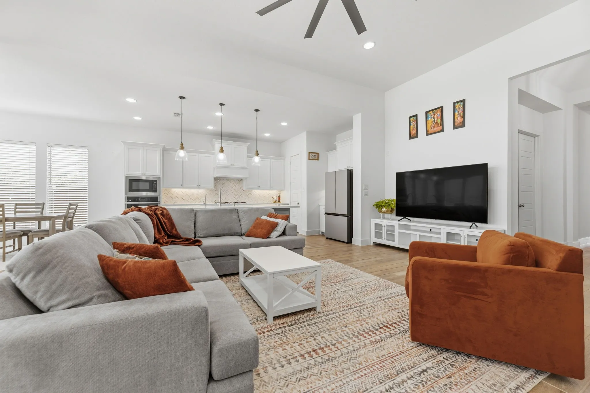 Open-concept living space featuring wood-finish flooring, recessed lighting, and a ceiling fan