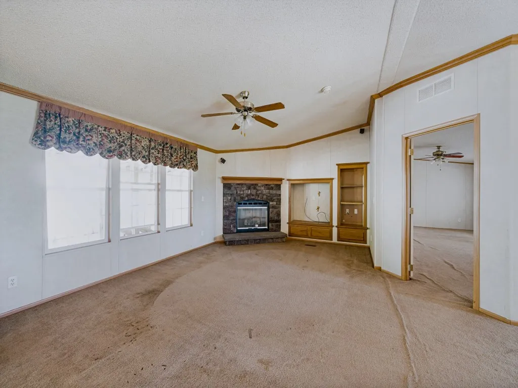 Living area featuring a fireplace, built-in shelving, and multiple windows