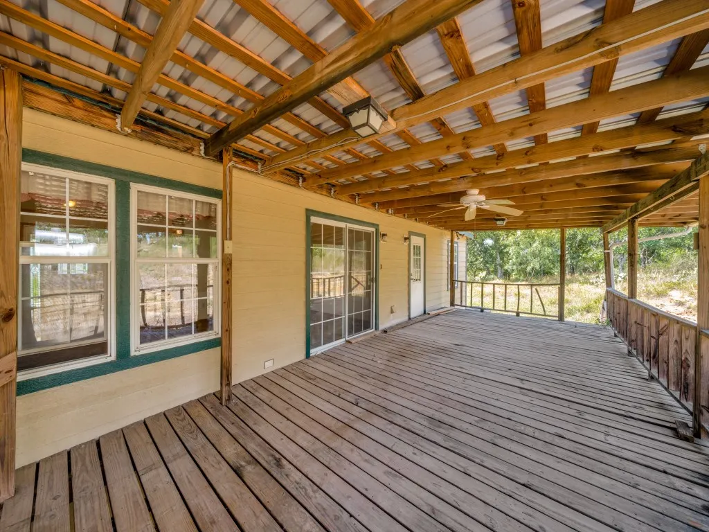Spacious covered porch featuring wood-finish flooring and ceiling fan