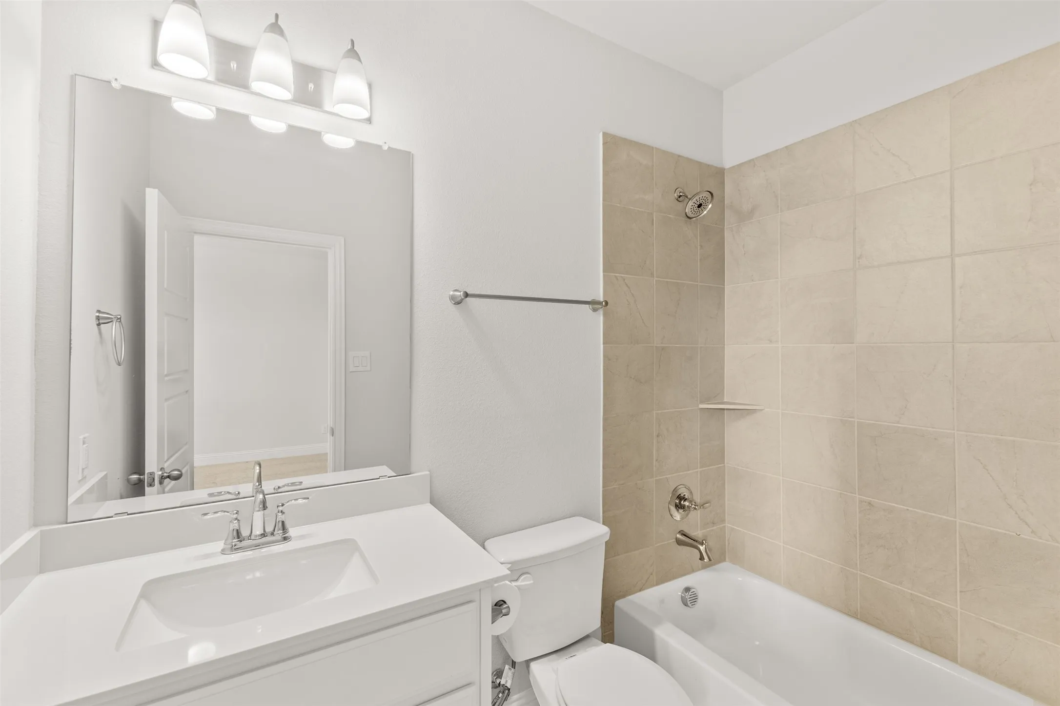 Bathroom featuring a white vanity with an integrated sink, chrome faucet, and a large wall-mounted mirror