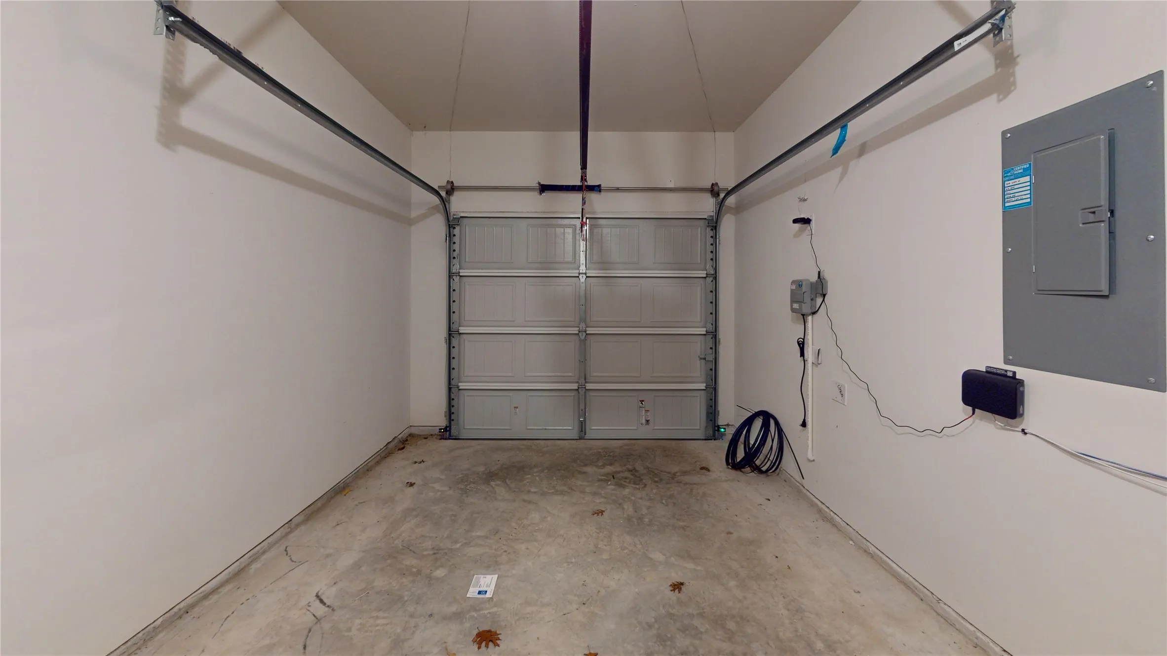 Attached garage with a concrete floor, painted walls, and an overhead garage door