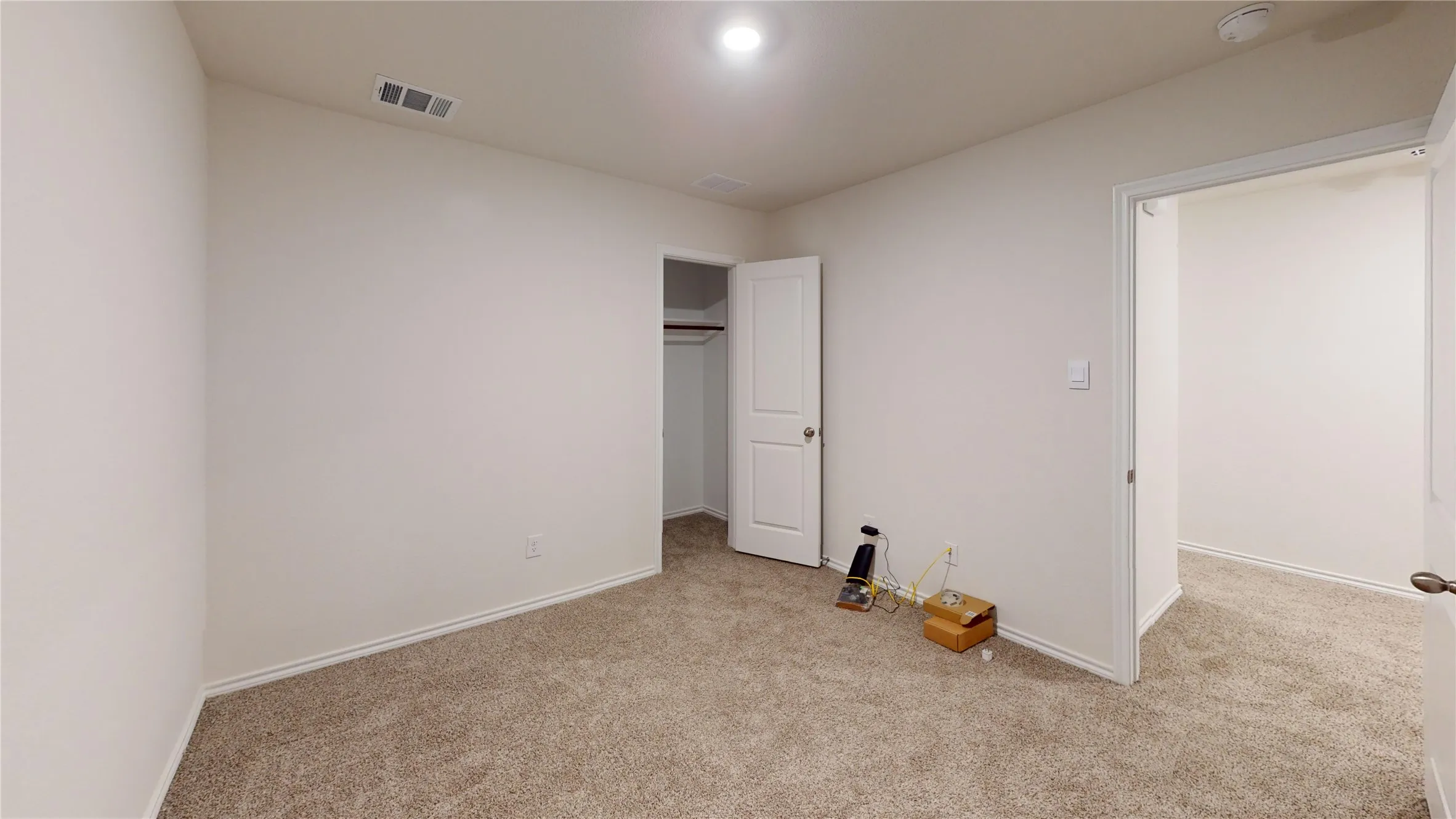 Carpeted room with neutral paint finishes and overhead lighting
