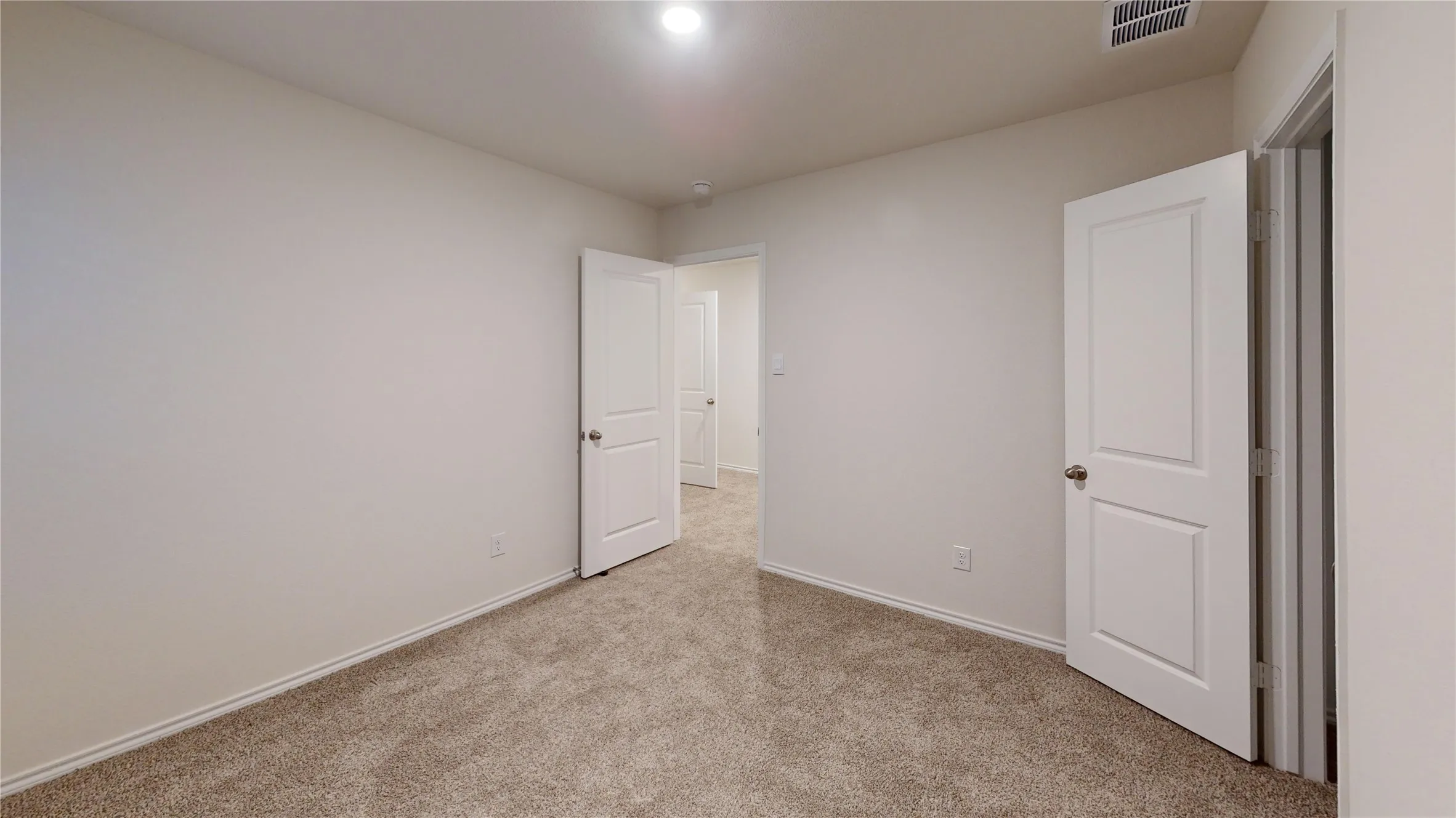 Room featuring neutral-toned carpet flooring and light-colored walls