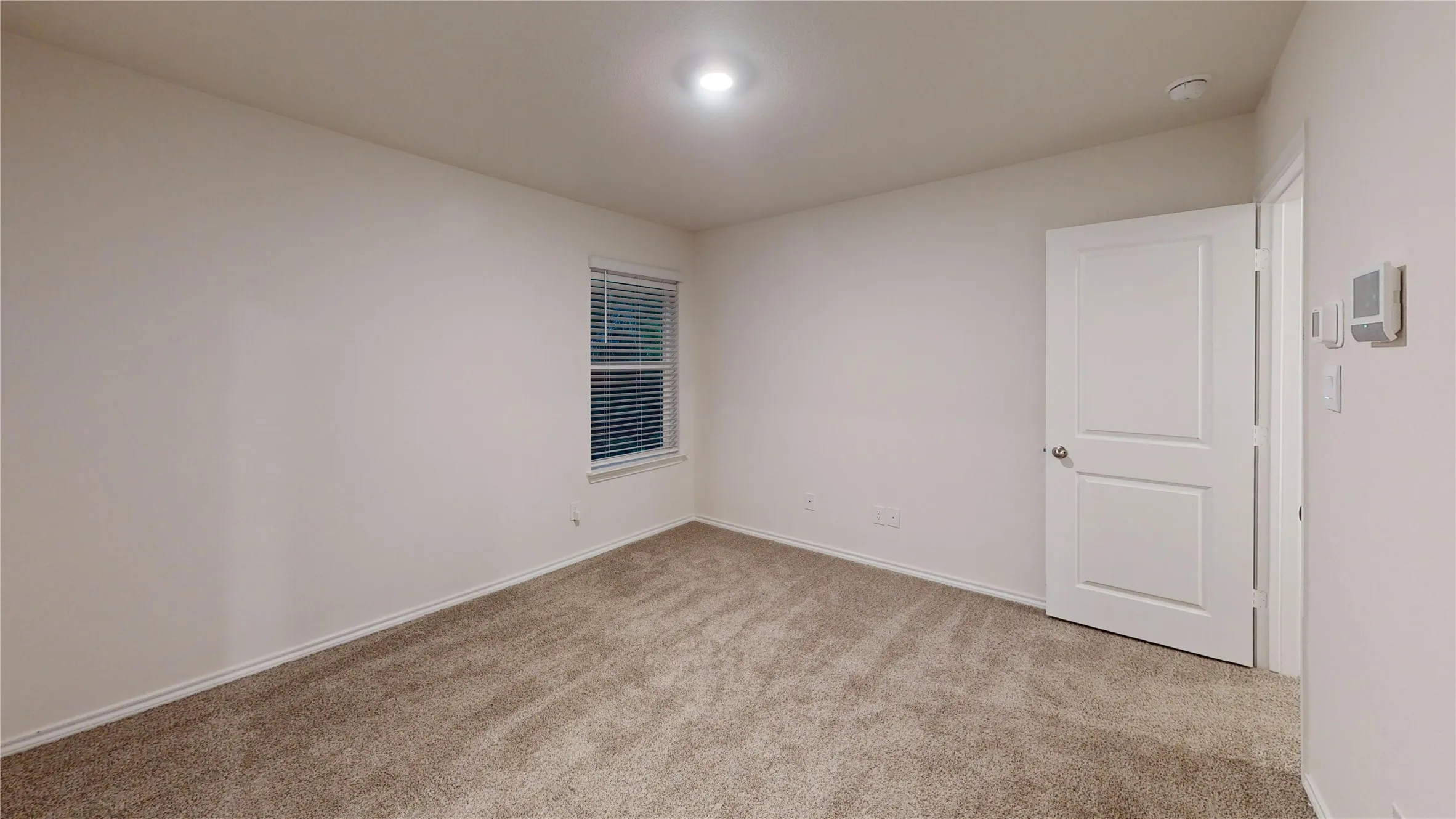 Neutral wall paint, plush carpet flooring, recessed ceiling lighting, and a white paneled door