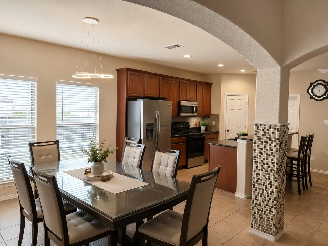 Open-concept dining area featuring a modern linear chandelier and tile flooring