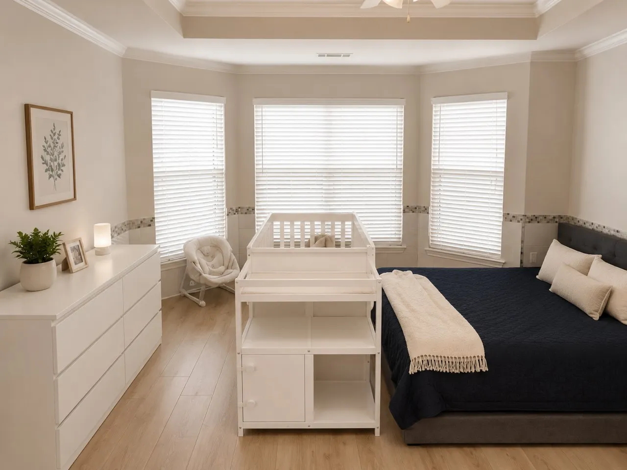 Bright bedroom featuring a bay window with multiple natural light sources, a tray ceiling, crown molding, and wood-finish flooring