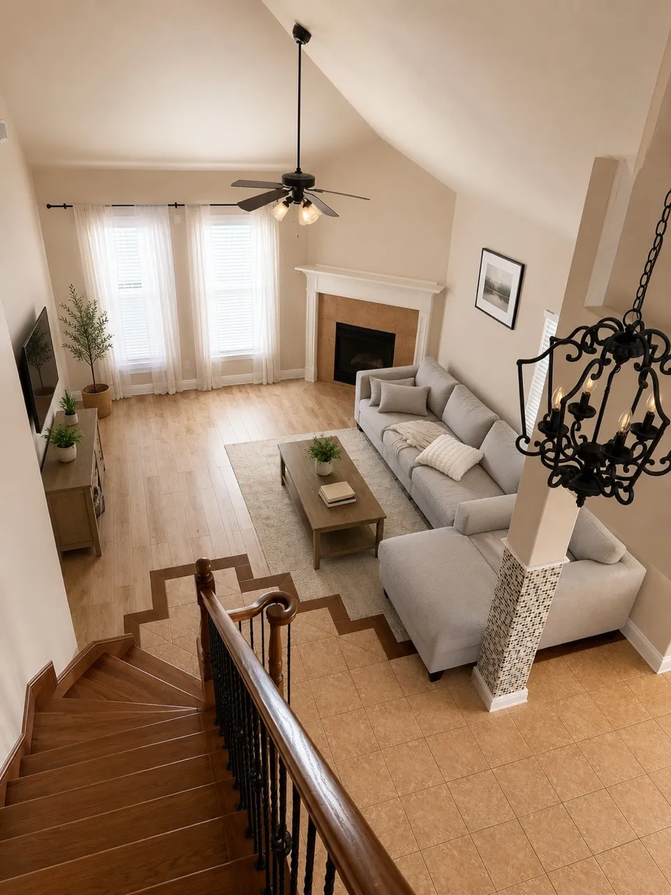 Vaulted ceiling living area featuring a fireplace with a white mantel, wood-finish flooring, and two large windows