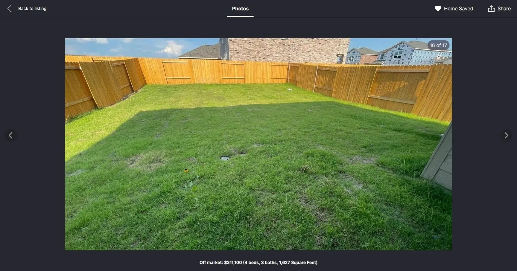 Expansive backyard featuring a manicured lawn, full perimeter wood fencing, and a visible portion of the home's exterior siding
