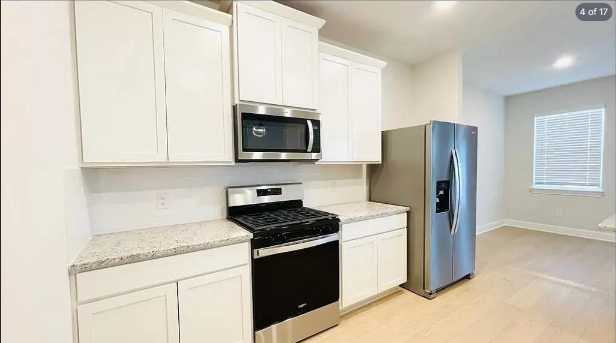 Kitchen featuring white shaker-style cabinetry, granite countertops, stainless steel appliances, and subway tile backsplash