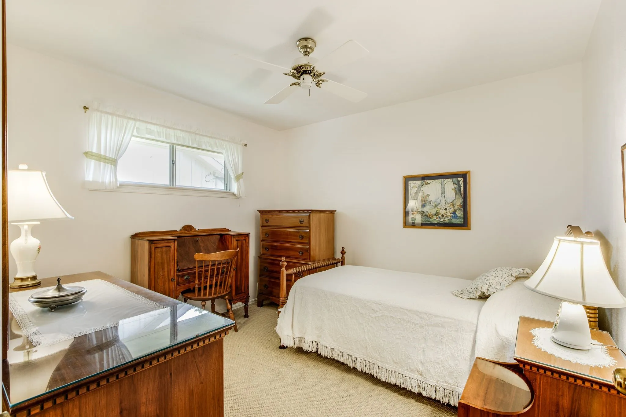 Light-filled room featuring a broad window, neutral-toned carpeting, and a ceiling fan with integrated lighting