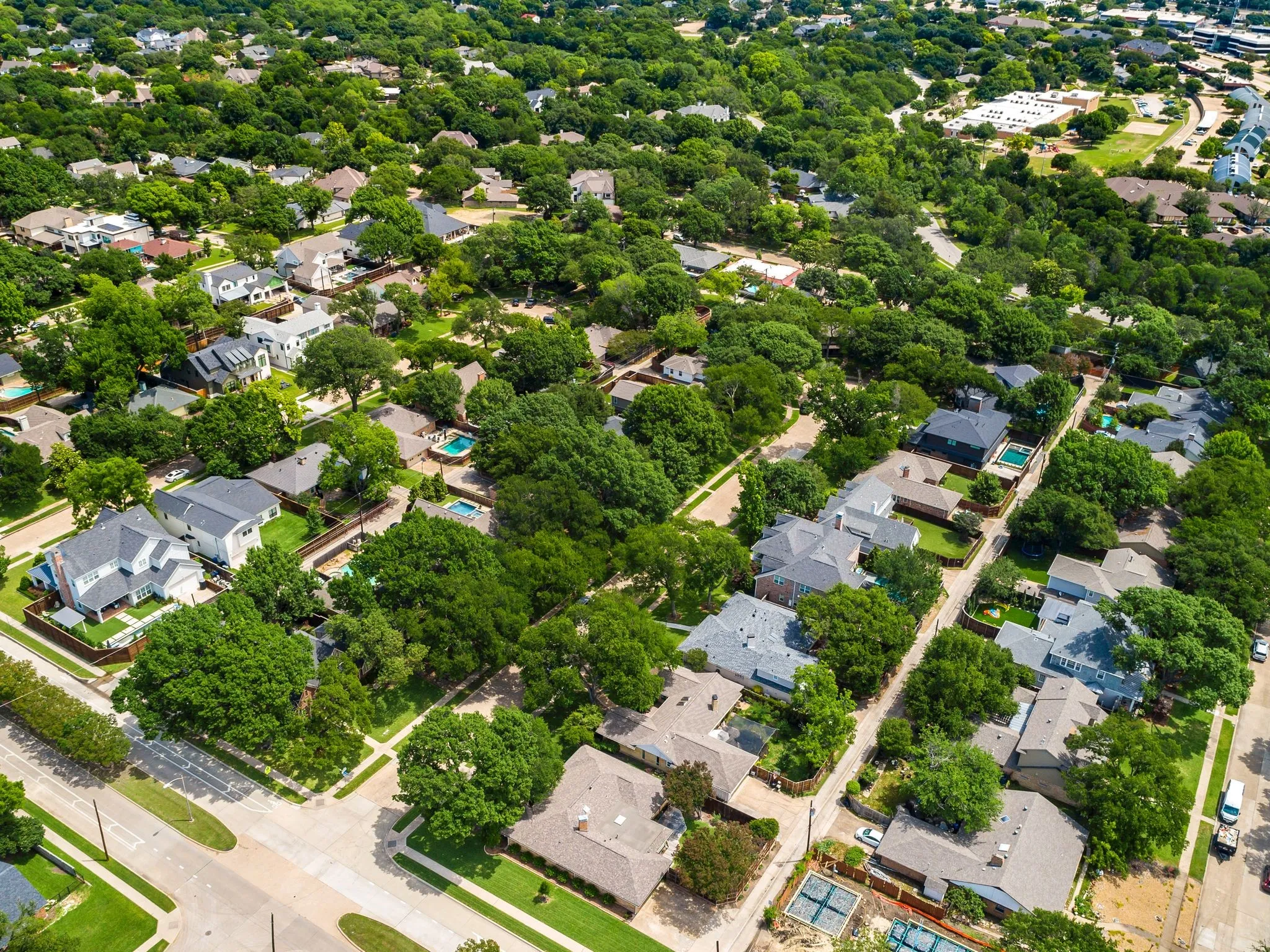Aerial perspective showcasing a residential area with extensive mature tree coverage
