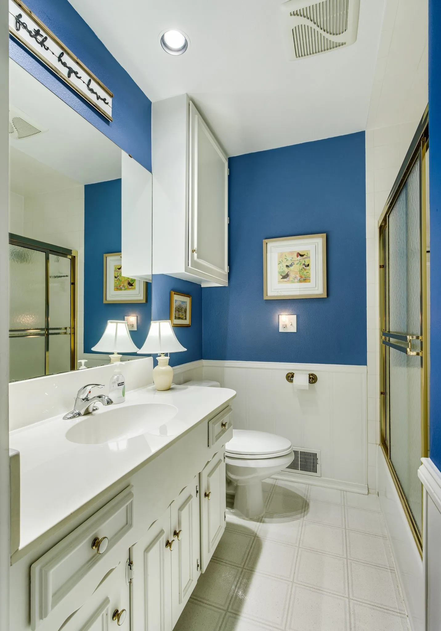 Bathroom featuring a white vanity with an integrated sink, polished chrome faucet, and a large mirror