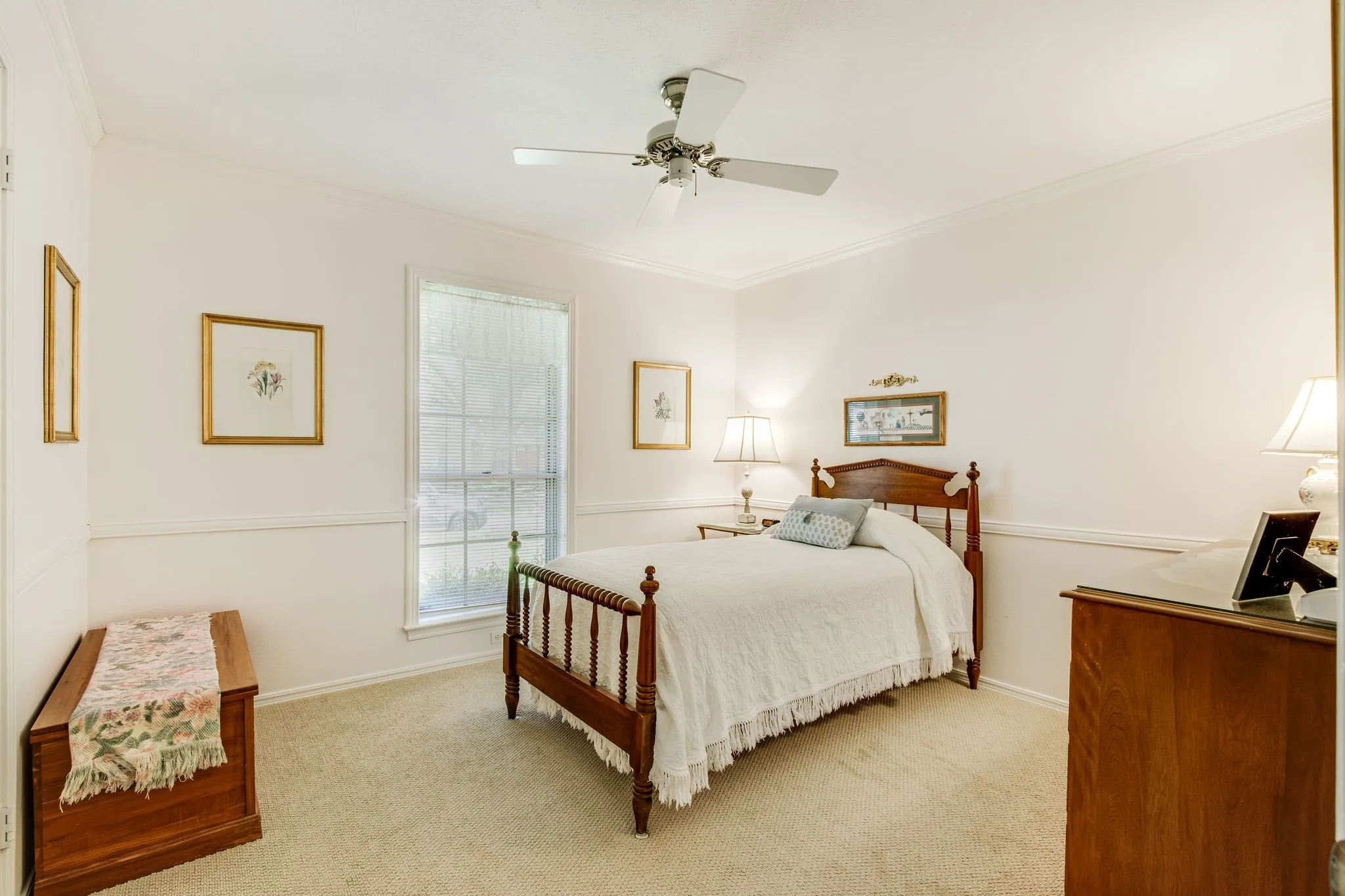 Neutral tone wall finish with crown molding, chair rail molding, a ceiling fan, and carpet flooring