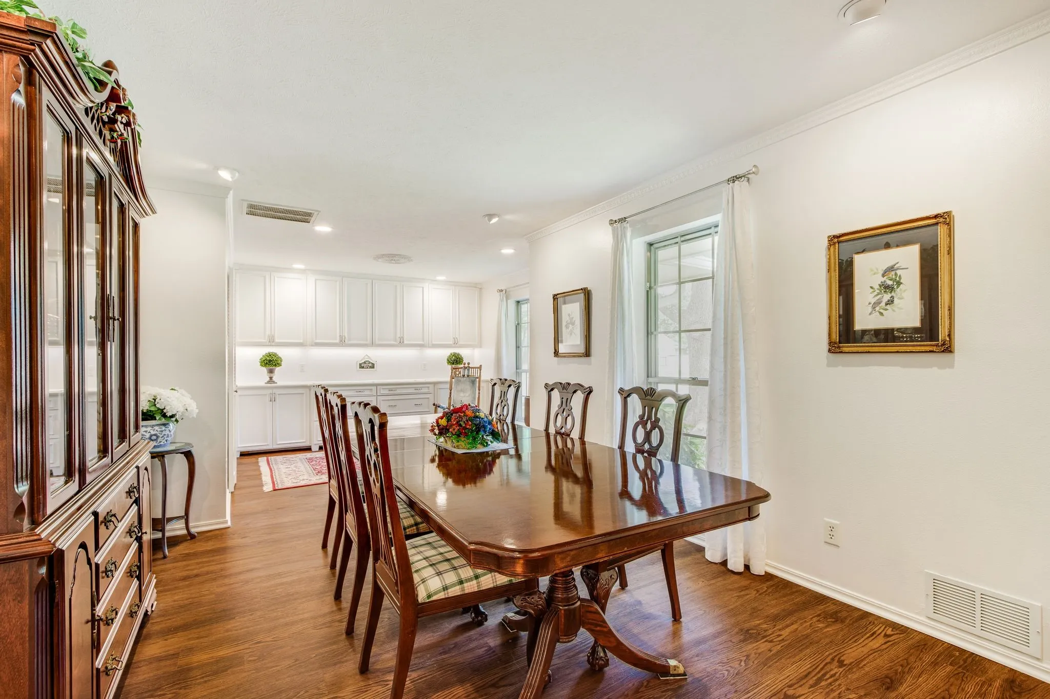 Spacious dining area featuring wood-finish flooring, white crown molding, and recessed lighting