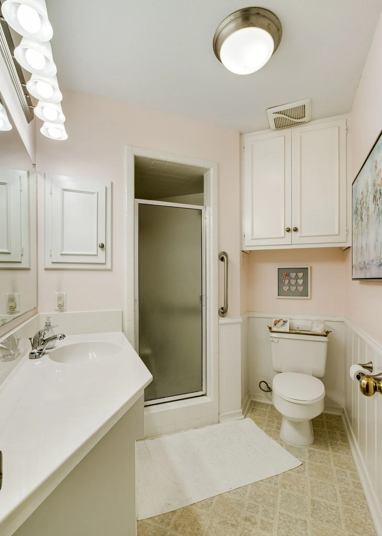 Bathroom featuring a single vanity, built-in medicine cabinet, and a shower with a frosted glass door