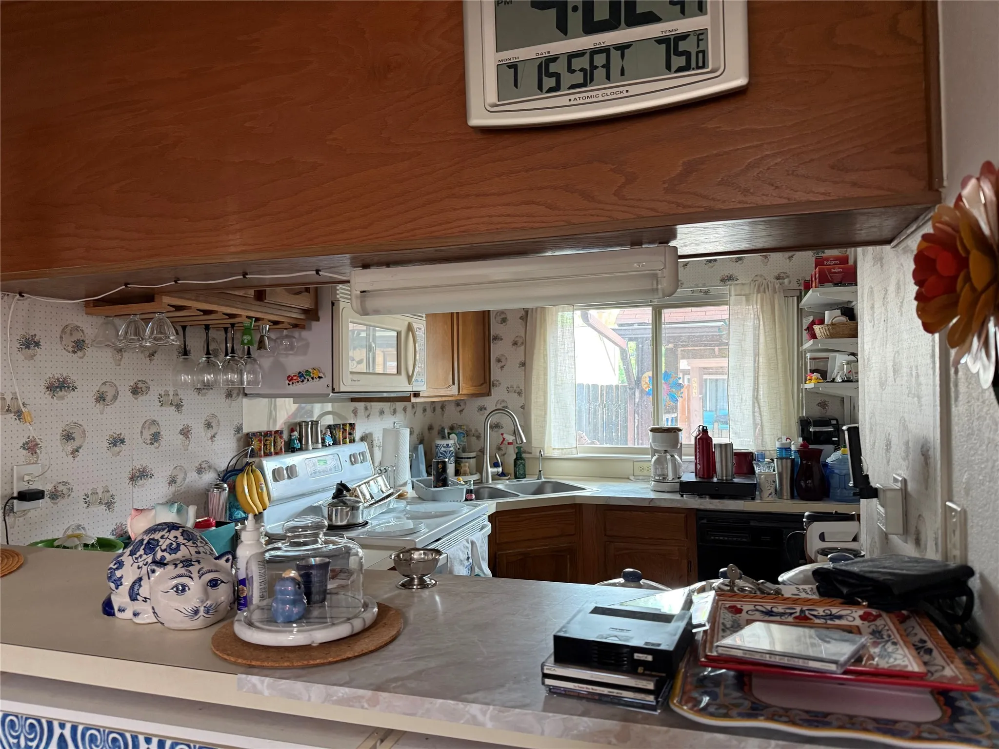 Kitchen featuring wood-finish cabinetry, a double basin sink, and a built-in dishwasher
