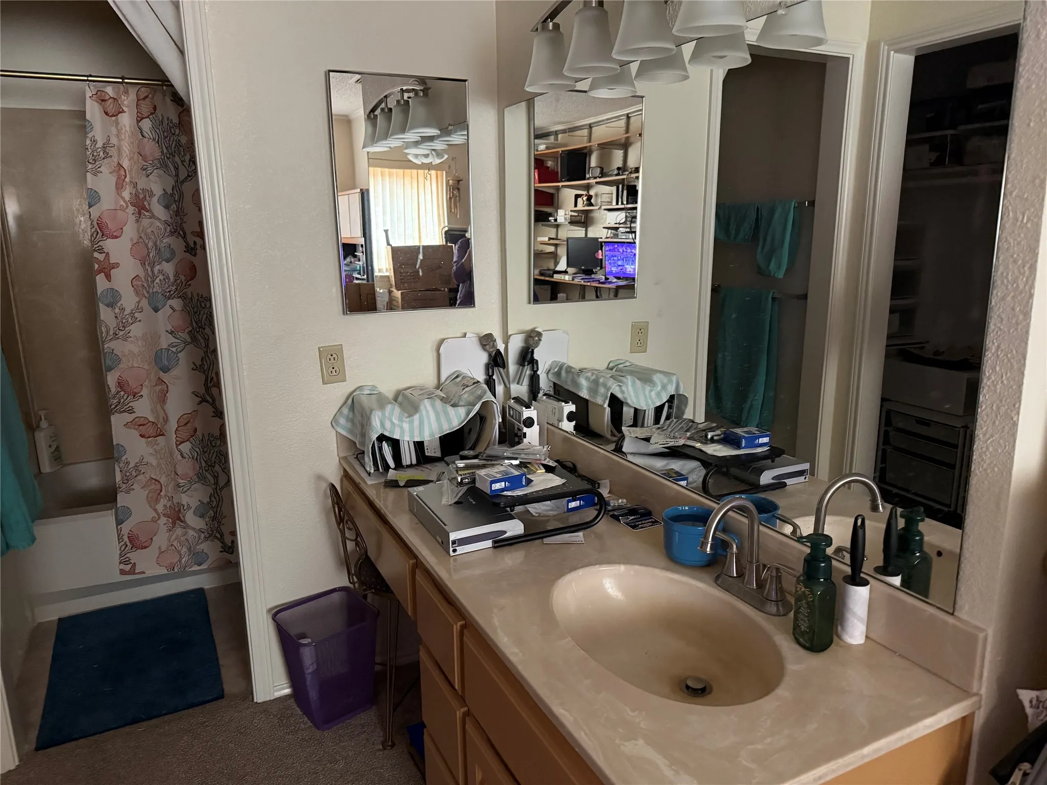 Bathroom vanity featuring a single basin sink, laminate countertop, and wood-finish cabinetry