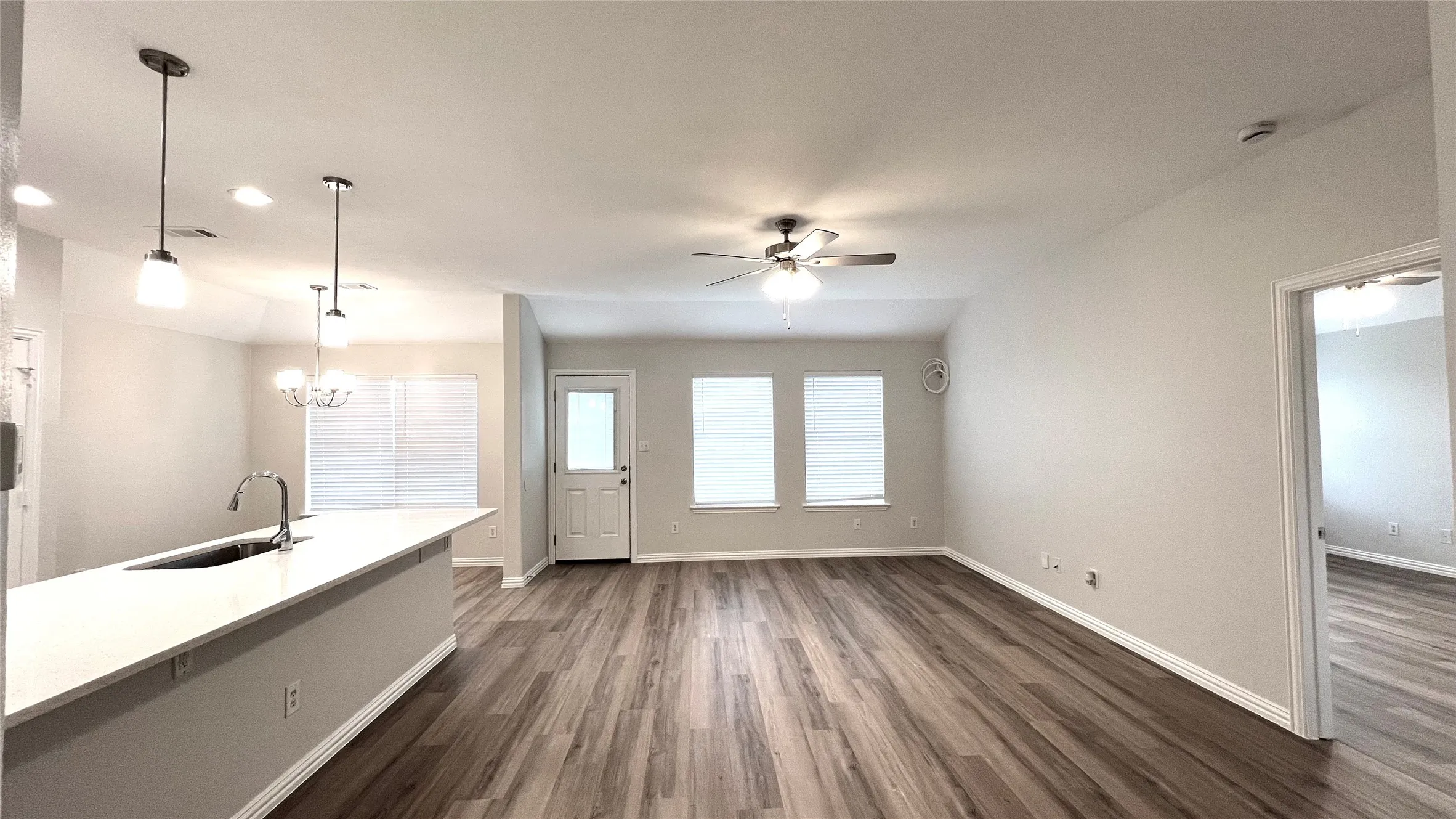 Open-concept living space featuring wood-finish flooring, recessed lighting, and a ceiling fan