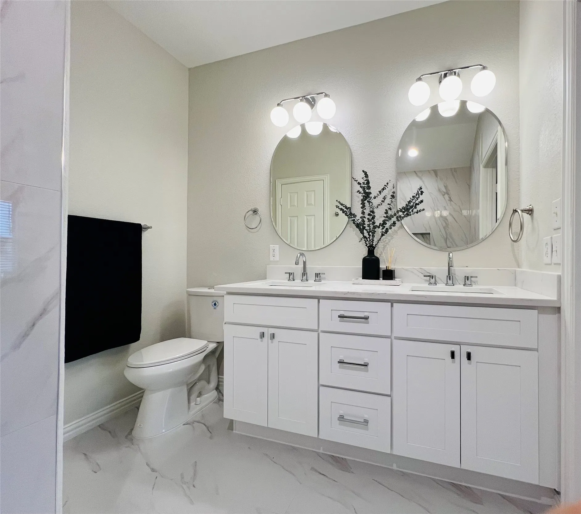 Dual vanity featuring white shaker cabinetry, quartz countertops, and chrome hardware