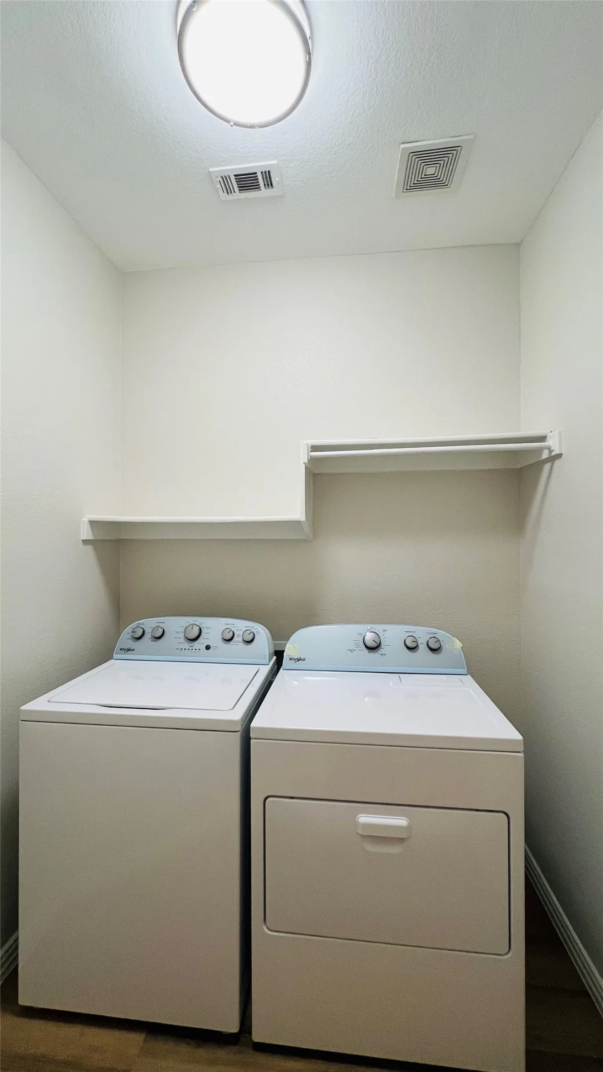 Dedicated laundry space featuring wood-finish flooring and a flush-mount ceiling light