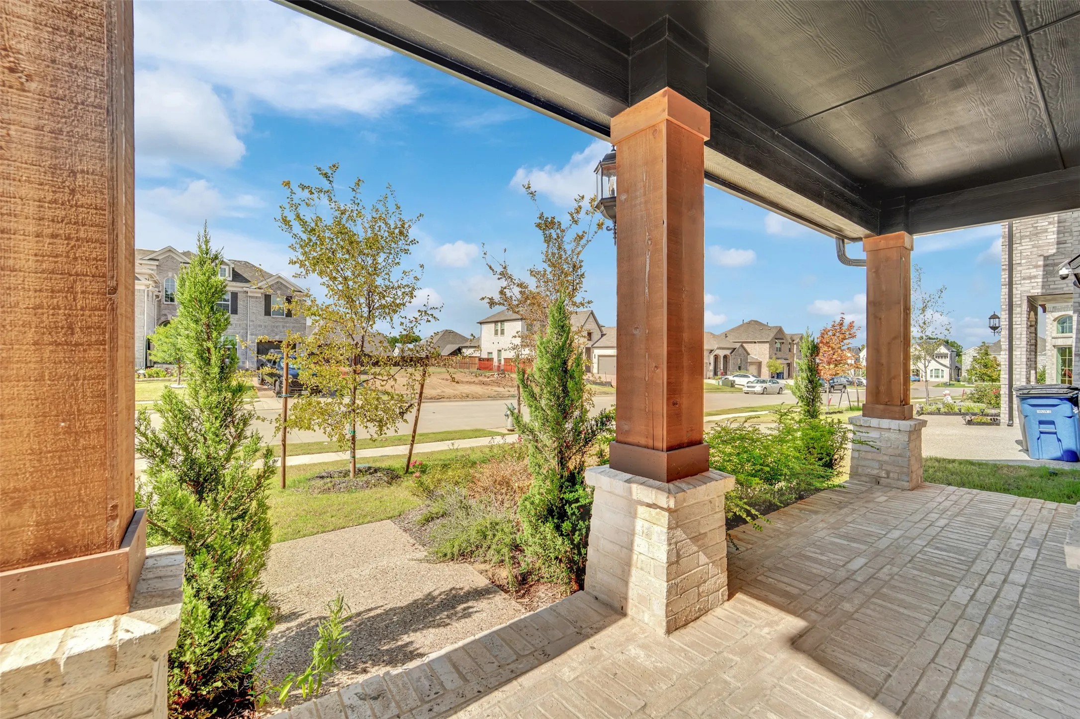 Covered front porch featuring wood-finish columns with stone bases