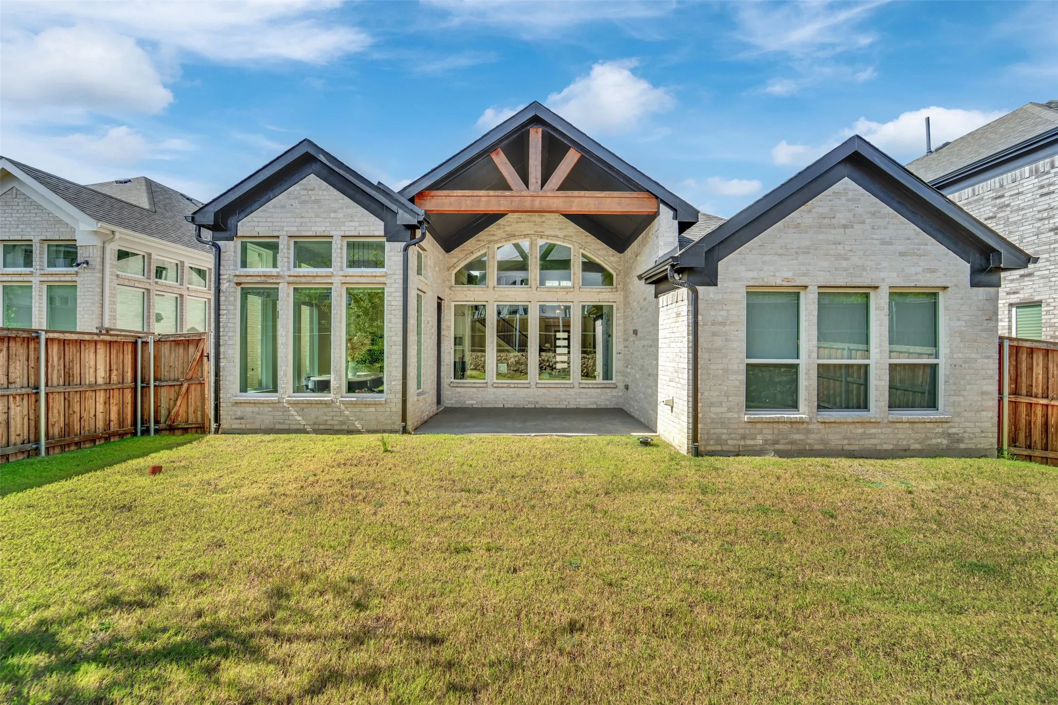 Rear exterior featuring light-toned brick, dark trim, and a gabled roofline