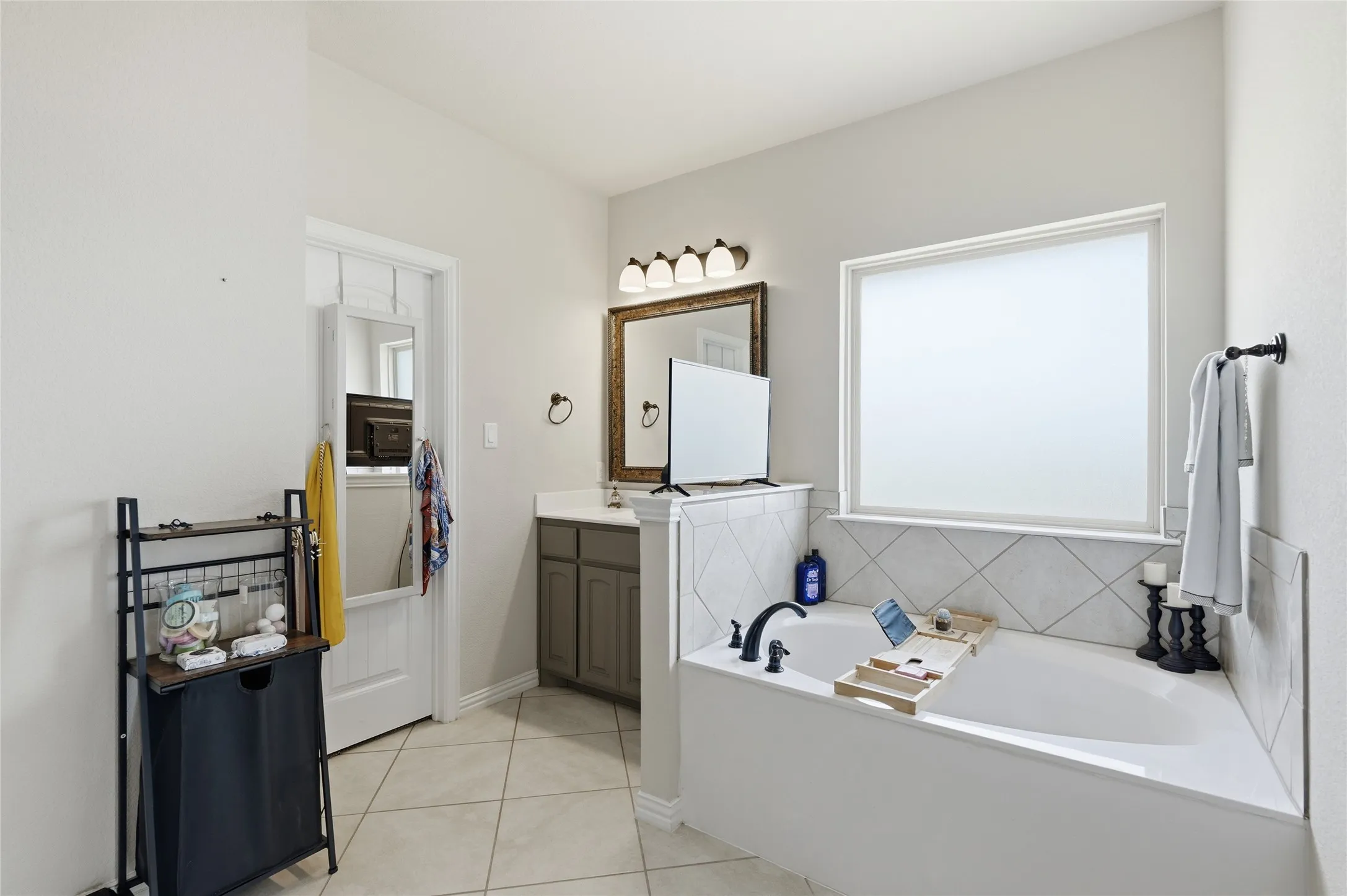 Soaking tub featuring a tiled surround with a frosted window